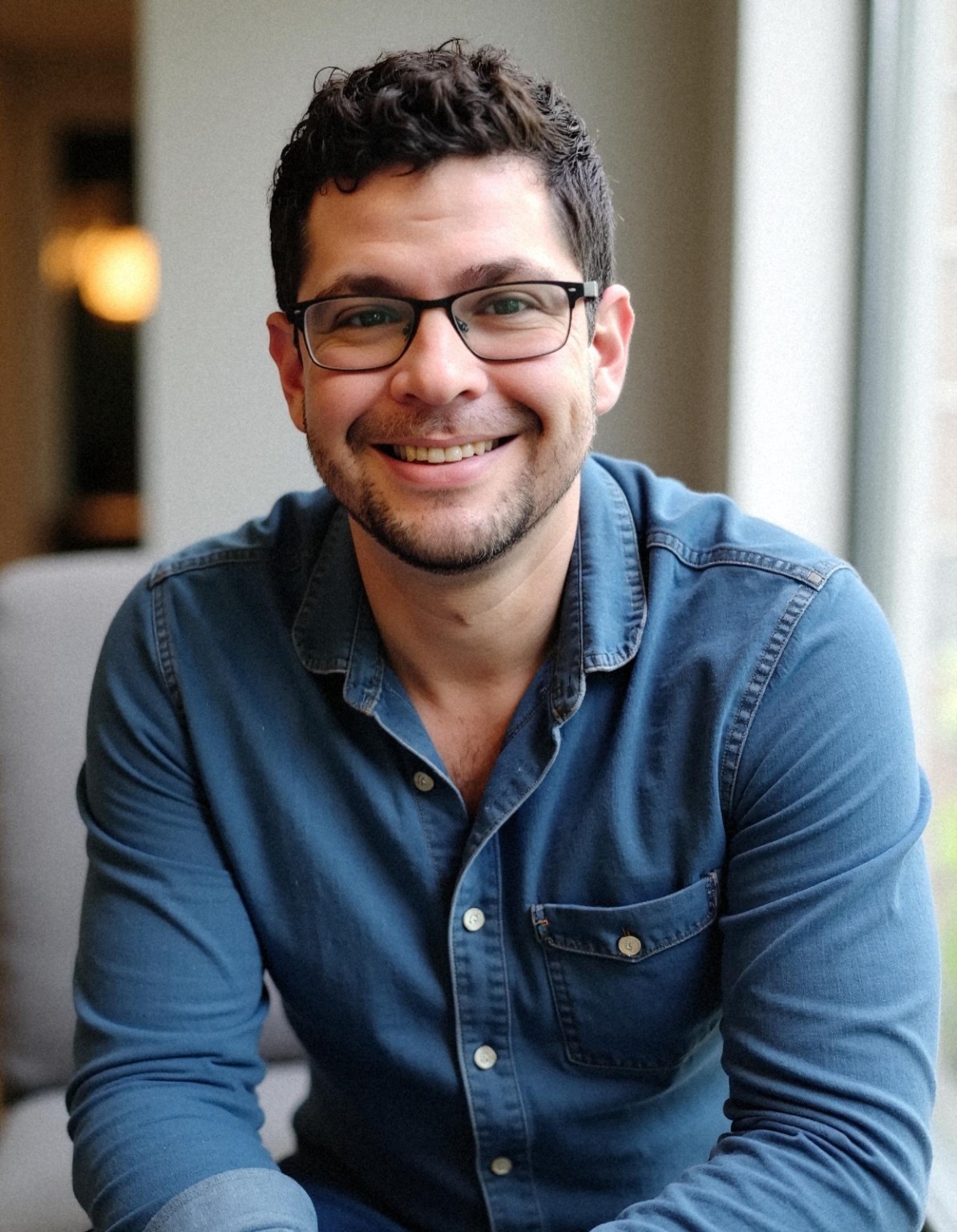 Yishai Silber, founder of Dignity, smiling in a blue shirt and glasses